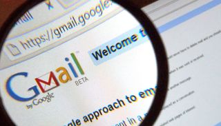 Büyüteç altında bilgisayar ekranındaki Gmail logosu.