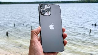 iPhone 13 Pro Max, suyun önünde tutulan gri renkte