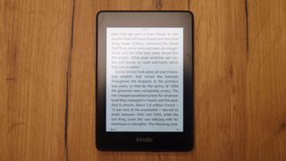 Bir Kindle Paperwhite ahşap bir masanın üzerine oturdu.