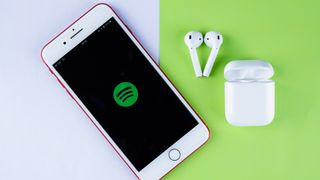 iphone'da bir çift airpod'un yanında spotify