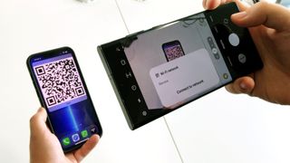 iPhone 13 Pro Max'ten bir Wi-Fi QR kodunu tarayan Samsung Galaxy S22 Ultra, iPhone'dan Android'e wi-fi şifresinin nasıl paylaşılacağı hakkında bir makaleyi temsil ediyor