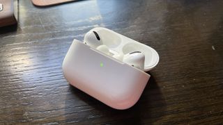 İçinde AirPods Pro bulunan ve yeşil ışığı yanan bir AirPods Pro kasası açık