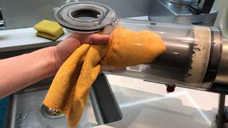 Dyson V11 kutusu nemli bir mikrofiber bezle temizleniyor