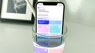 iPhone'dan suyun nasıl çıkarılacağını gösteren suda bir iPhone