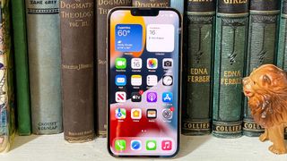 kitaplara yaslanmış iphone 13 pro ekranı