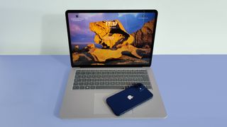 Telefonu klavyenin üzerinde duran bir MacBook