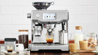 Damlama tepsisinde bir fincan espresso bulunan bir Breville Oracle Touch espresso makinesi