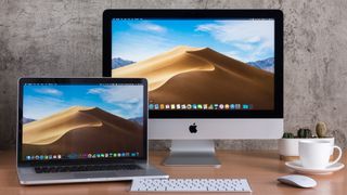 Ev ofisinde bir masa üzerinde Apple MacBook ve Apple iMac