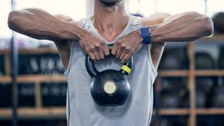 kettlebell kullanarak dik kürek çeken bir adamın fotoğrafı