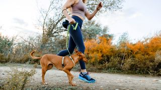 köpeğiyle koşan bir kadının fotoğrafı