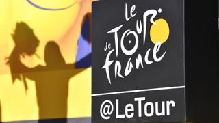 Podyumda sarı mayo liderinin silueti ile Tour de France logosu