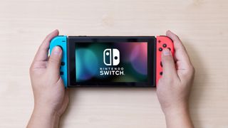 Nintendo Switch'te karanlık mod nasıl etkinleştirilir - Nintendo Switch tutan adam