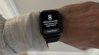 Kilit seçeneğiyle bir iPhone'un kilidini açtığını gösteren bir Apple Watch